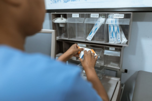 Medical professional selecting products from a shelf representing supplier evaluation and quality verification practices.