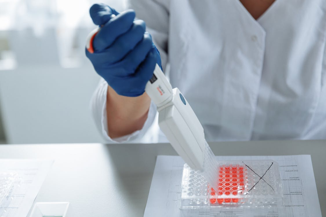 Laboratory technician handling capsule preparation representing quality control and supplier verification in biomedical products.